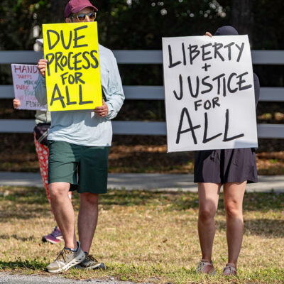 A protest with individuals holding signs in favor of due process.