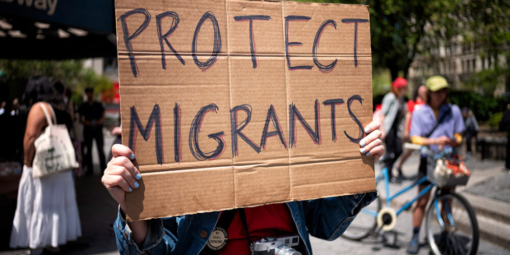 A demonstrator holding a sign that says "Protect Immigrants."