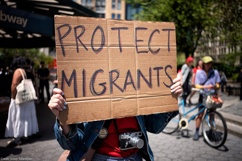 A demonstrator holding a sign that says "Protect Immigrants."