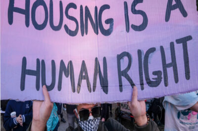 Activists and people experiencing homelessness gather near tents housing the homeless at an encampment in Echo Lake Park as the city makes plans to evict all the parks encampments in Los Angeles, March 24, 2021.
