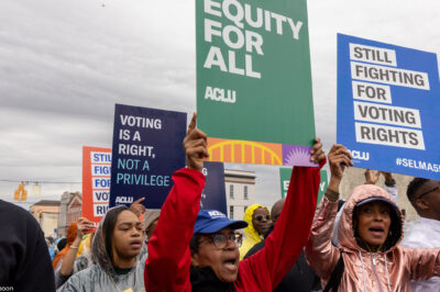 A group of voting rights advocates marching over the Edmund Pettus Bridge.