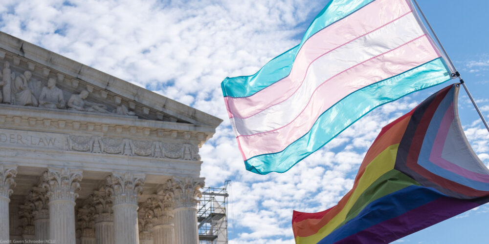 The Trans and LGBTQ+ flags waving in the wind in front of the Supreme Court Building in DC.