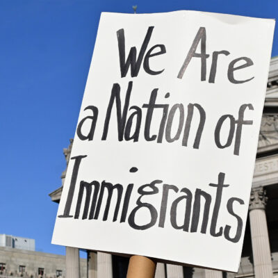 Two signs are held up during the May Day March In Manhattan, New York on May 1, 2025. The largest of the signs is in the foreground and reads"We Are a Nation of Immigrants," while the smaller in the background reads, " WE ARE ALL (EXCEPT NATIVE AMERICANS) IMMIGRANTS! PUT I.C.E. ON ICE NOW".