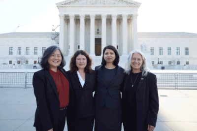Cecillia Wang and others standing on the front steps in front of the Supreme Court